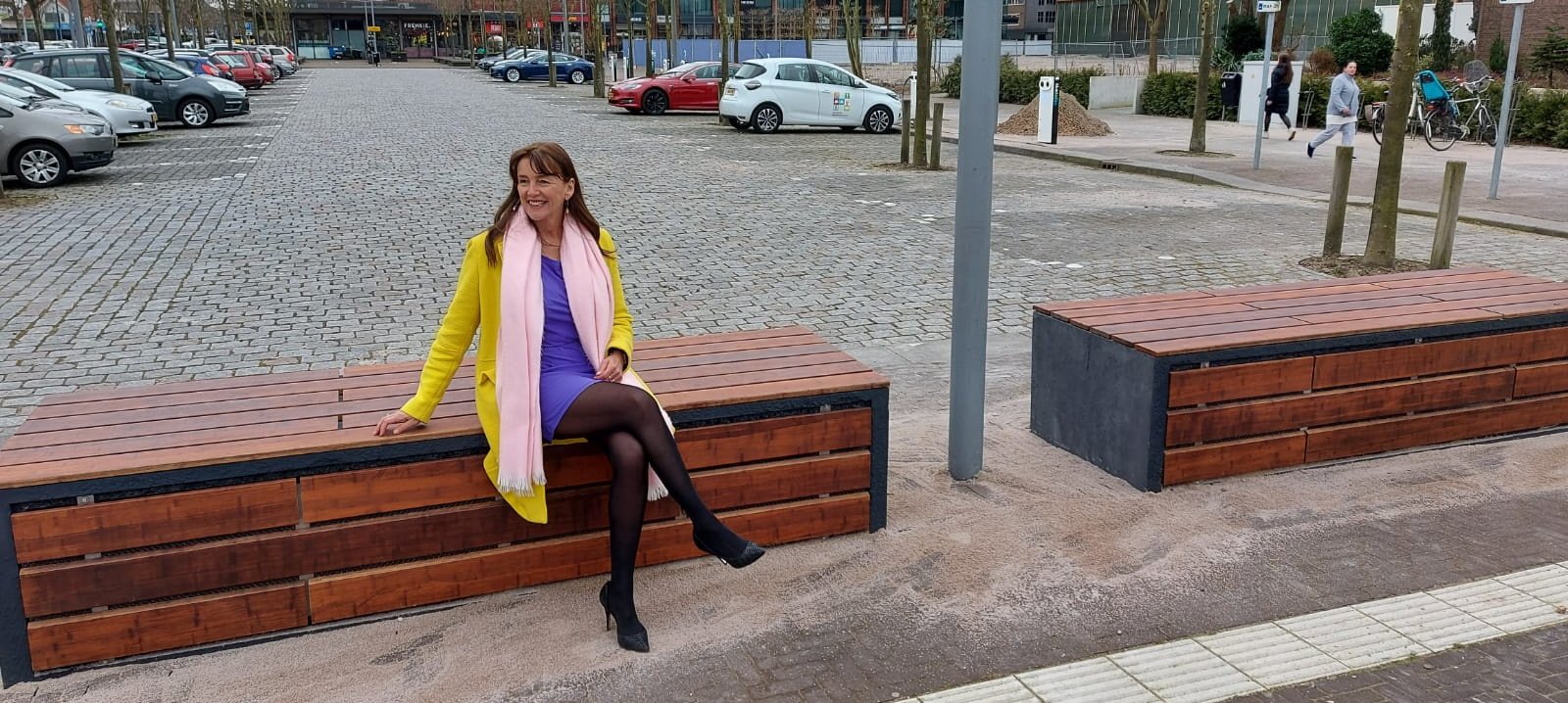 Wethouder Marja Ruigrok zittend op de batterij die is geïntegreerd in het straatmeubilair 